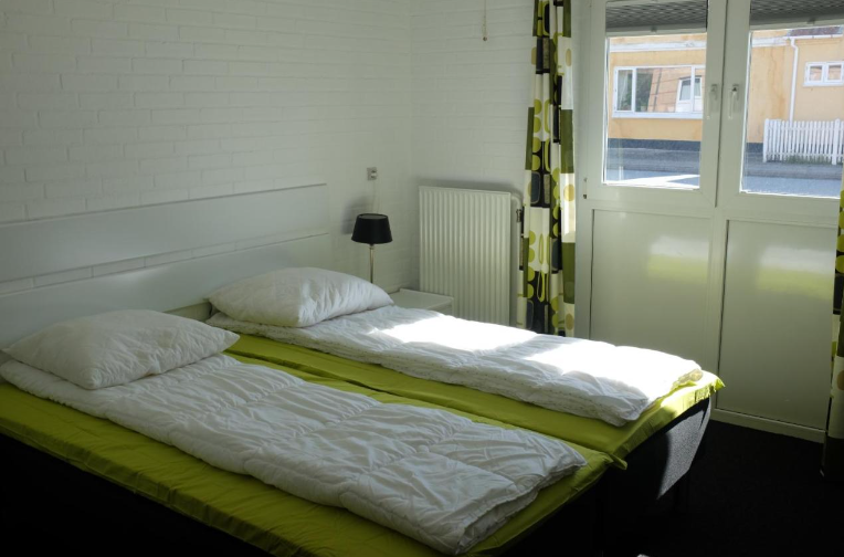 Værelse med senge og vinduer på hostel i Løkken